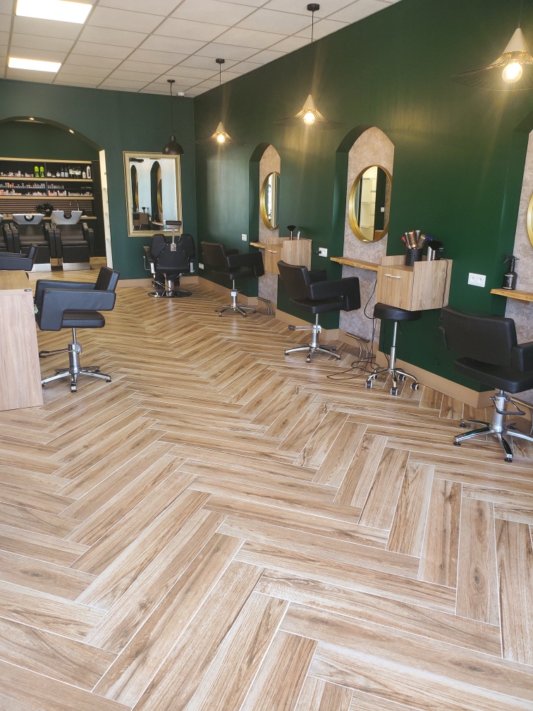 Postes de coiffure et miroirs ovales sur mur vert